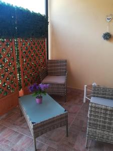 シニスコーラにあるPiccolo accogliente monolocaleのパティオ(椅子2脚、紫の花のテーブル付)