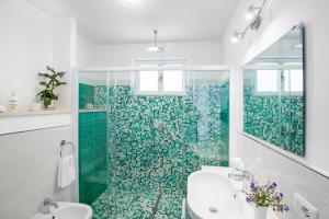 baño con lavabo y ducha con azulejos verdes en La Borragine Apartament en Positano