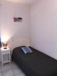 a bedroom with a bed and a table with a lamp at Residence Plage Oceane in Biscarrosse-Plage