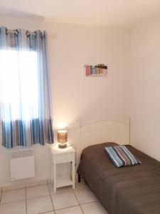 a bedroom with a bed and a lamp on a table at Residence Plage Oceane in Biscarrosse-Plage
