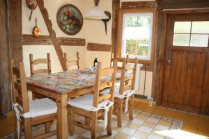 a dining room with a wooden table and chairs at Historisches Küsterhaus Reetdachträume in Putzar