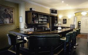 a bar with leather chairs and a bar counter at Parkhotel Helmstedt in Helmstedt