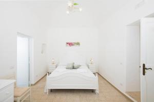 1 dormitorio blanco con 1 cama y 2 mesas en La Borragine Apartament en Positano
