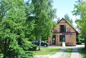 ein Gebäude mit einem davor geparkten Auto in der Unterkunft Camping Marco Polo in Łeba