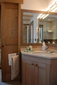 een badkamer met een wastafel en een grote spiegel bij Affittacamere Lou Ressignon in Cogne