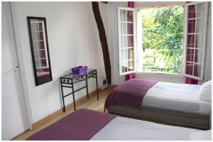 - une chambre avec 2 lits et une fenêtre dans l'établissement Ferme de Launay, à Chançay