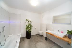 ein weißes Bad mit einem Waschbecken und einem WC in der Unterkunft Hotel Restaurant Sailer in Seewalchen