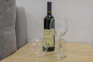 eine Flasche Wein und zwei Gläser auf einem Tisch in der Unterkunft Peninsula room in Zadar