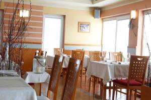ein Esszimmer mit weißen Tischen und Stühlen und Fenstern in der Unterkunft Sobe Grabar in Ptuj