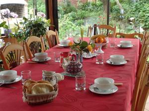un tavolo con una tovaglia rossa con sopra del cibo di Chambre d'Hôtes Broualeuc a Saint-Potan