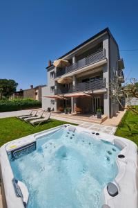 a house with a swimming pool in front of a house at Apartment Niko in Poreč