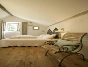 a bedroom with a bed and a bench in it at La Grange à Nicolas in Baume-les-Messieurs