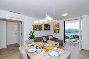 een eetkamer en een woonkamer met een tafel en stoelen bij Apartments Lazarin in Dubrovnik
