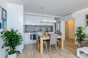 eine Küche und ein Esszimmer mit einem Holztisch und Stühlen in der Unterkunft Apartments Lazarin in Dubrovnik + 37 Fotos