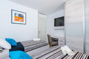 ein Schlafzimmer mit zwei Betten und einem Schreibtisch in der Unterkunft Apartments Lazarin in Dubrovnik