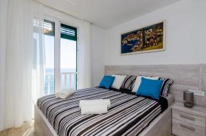 ein Schlafzimmer mit einem großen Bett mit blauen und weißen Kissen in der Unterkunft Apartments Lazarin in Dubrovnik