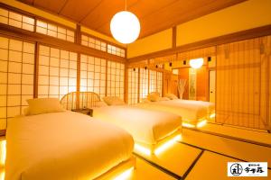 a room with three beds with lights in it at Konjaku-So Dotonbori Penthouse Stay in Osaka