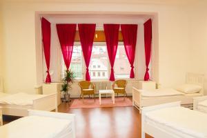 a room with beds and a window with red curtains at Hostel Franz Kafka in Prague