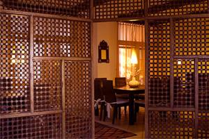 un comedor con mesa y una habitación con paredes de madera. en Garni Cremona, en Bresanona