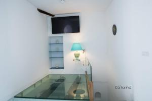 una camera con tavolo in vetro e lampada di Ca'Turino a Vietri