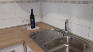 a kitchen counter with a sink and a bottle of wine at Renato in Bašanija
