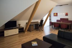 ein Wohnzimmer mit einem Tisch und einem TV sowie ein Esszimmer in der Unterkunft Langs Wirtshaus in Sankt Ulrich im Mühlkreis