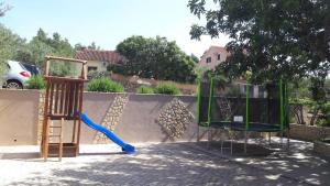 un parque infantil con un tobogán azul y un columpio en Apartments Ena, en Vrboska