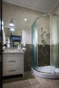 La salle de bains est pourvue d'une douche, d'un lavabo et d'un miroir. dans l'établissement Time Hotel, à Kiev