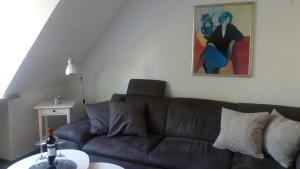 una sala de estar con un sofá marrón y una pintura en Ferienwohnung Brunnenstrasse, en Bremervörde