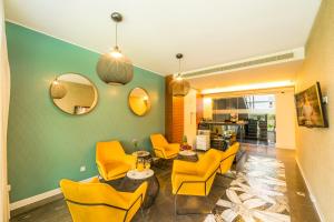 a lobby with yellow chairs and a table and mirrors at Rooms Oasis Life in Split