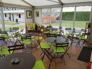 - un groupe de tables et de chaises dans une tente dans l'établissement Premiere Classe Amiens Est - Glisy, à Glisy