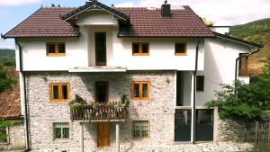 a white stone house with a balcony at Aste Guesthouse in Tropojë