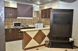 eine Küche mit einer Theke und einem Kamin in der Unterkunft منـازل الماسة للشقق المخدومة بريدة in Buraida