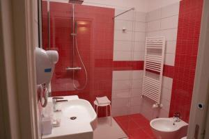 uma casa de banho vermelha com um lavatório e um chuveiro em Nidi di Feo em Lecce mais 37 fotografias