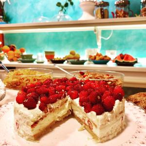 a piece of cake on a plate with strawberries on it at Sant'Agostino Suites & Rooms in Mazara del Vallo