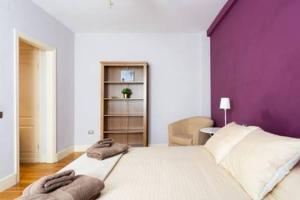a bedroom with a large bed with a purple wall at Piso Centrico Y Acogedor in Las Lagunas