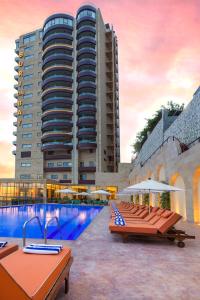 a hotel with a swimming pool in front of a building at BURJ ON BAY Hotel in Jounieh