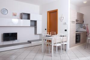 eine weiße Küche mit weißem Tisch und Stühlen in der Unterkunft June 13th Comfort Studio in Omegna
