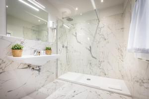 uma casa de banho branca com um lavatório e um chuveiro em Hotel Emma Small Luxury Hotel em Florença