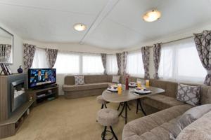 a living room with a couch and a table at Caravans Tattershall Lakes in Tattershall