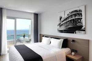 a hotel room with a bed and a painting on the wall at Poseidon Athens Hotel in Athens
