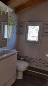 baño con aseo y lavabo y ventana en Casa Buena Vista, en Mundaka