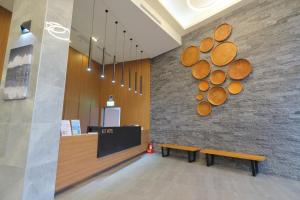 a lobby with a bench and a wall with logs at KET Hotel in Yuli