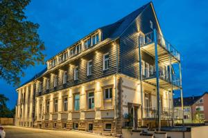 um antigo edifício de madeira com luzes acesas em AKZENT Hotel Villa Saxer em Goslar