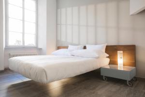 a bedroom with a large white bed and a table at Caffè dell'Arte Boutique Rooms Locarno in Locarno