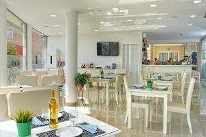 a dining room with white tables and white chairs at Palapart Gikas House in Gouvia