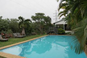 a large blue swimming pool next to a house at Dieu Donnee River Lodge in Port Shepstone