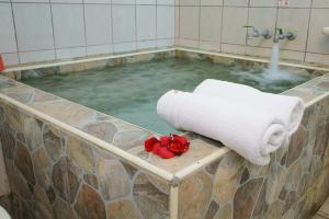 una piscina d'acqua con un asciugamano e fiori di 知本溫泉の旅宿 a Wenquan