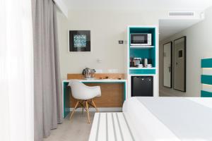 a bedroom with a white bed and a white chair at Vanilla Garden Boutique Hotel - Adults Only in Playa de las Americas