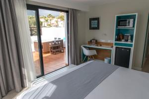 a bedroom with a bed and a view of a kitchen at Vanilla Garden Boutique Hotel - Adults Only in Playa de las Americas